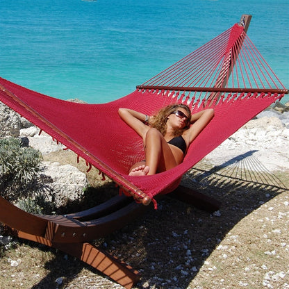 Woman relaxing in the Red Jumbo Caribbean Hammock on the Wood Arc Hammock Stand