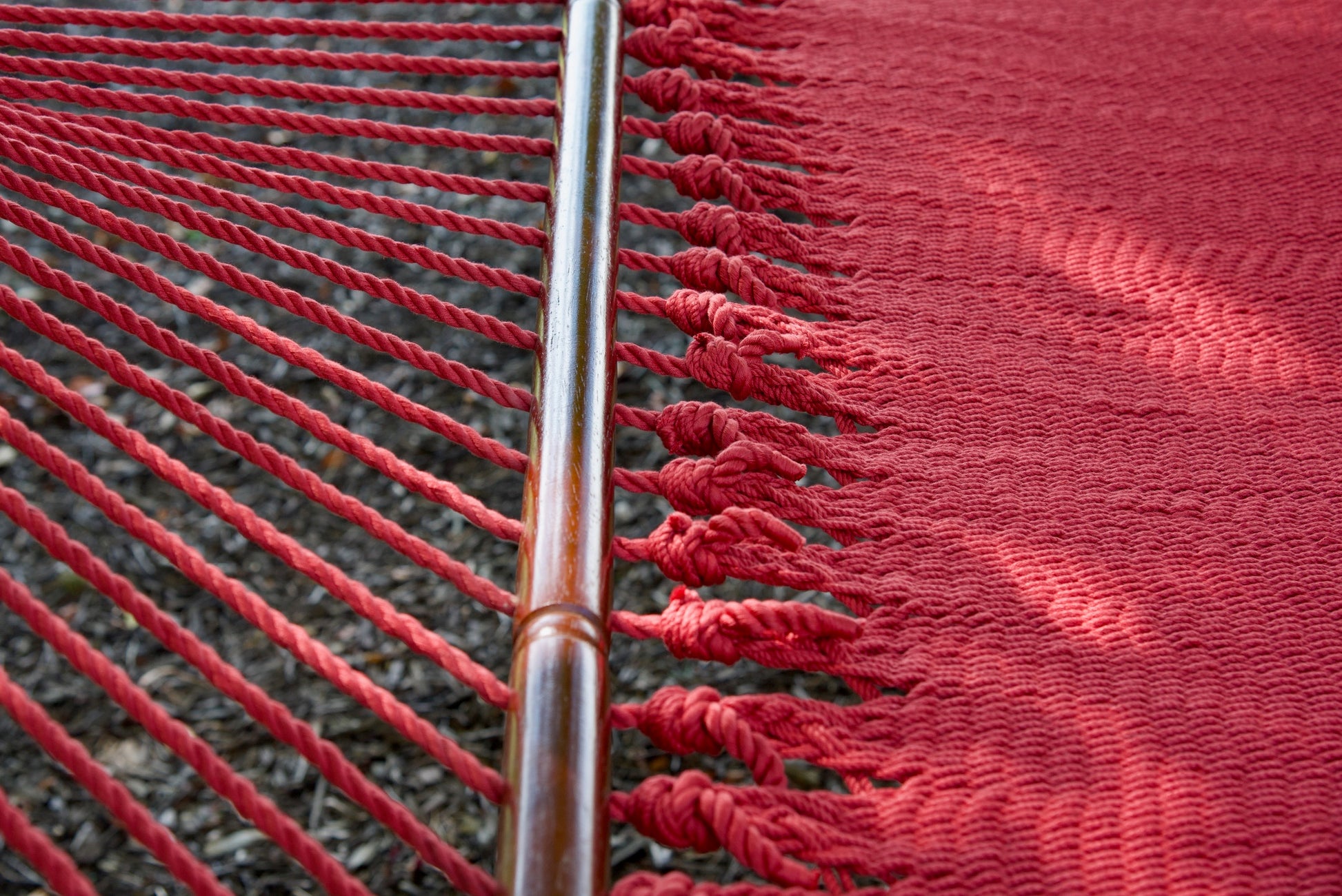End cords threaded through the drilled hardwood spreader bar of the Red Jumbo Caribbean Hammock