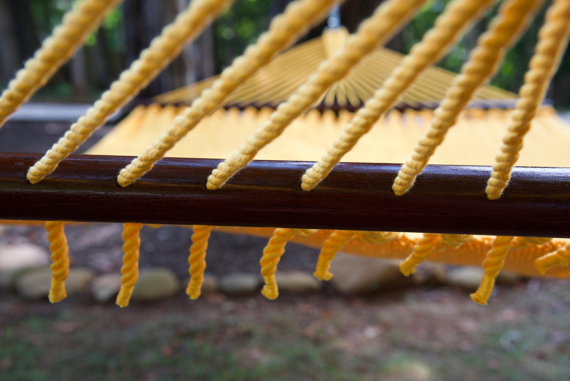 End cords threaded through the drilled hardwood spreader bar of the Yellow Jumbo Caribbean Hammock