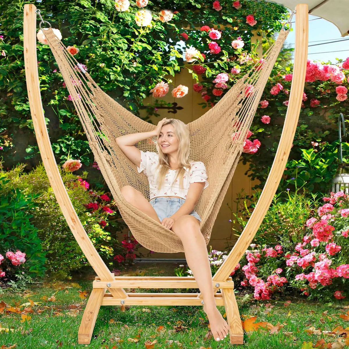Tan Jumbo Caribbean Recliner on a wood arc stand in a garden framed by climbing roses