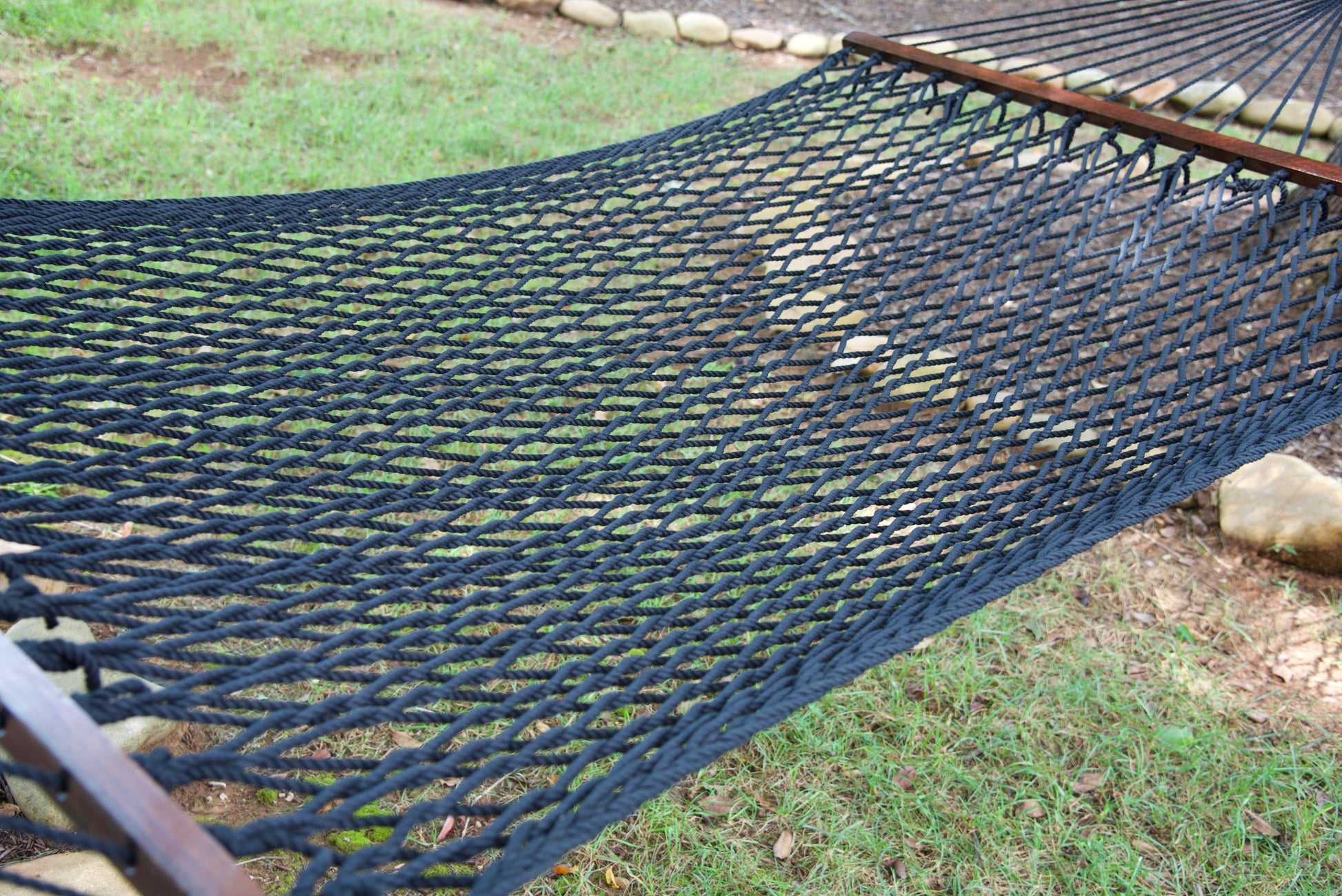 Close view of the Black polyester rope bed and wood spreader bar of the Jumbo Rope Hammock.