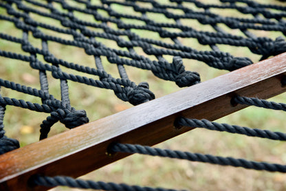 Close view of the varnished wood spreader bar and Black polyester rope of the Jumbo Rope Hammock.