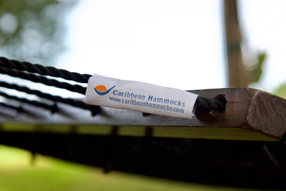 Caribbean Hammocks brand label on the wood spreader bar of the Black Jumbo Rope Hammock.