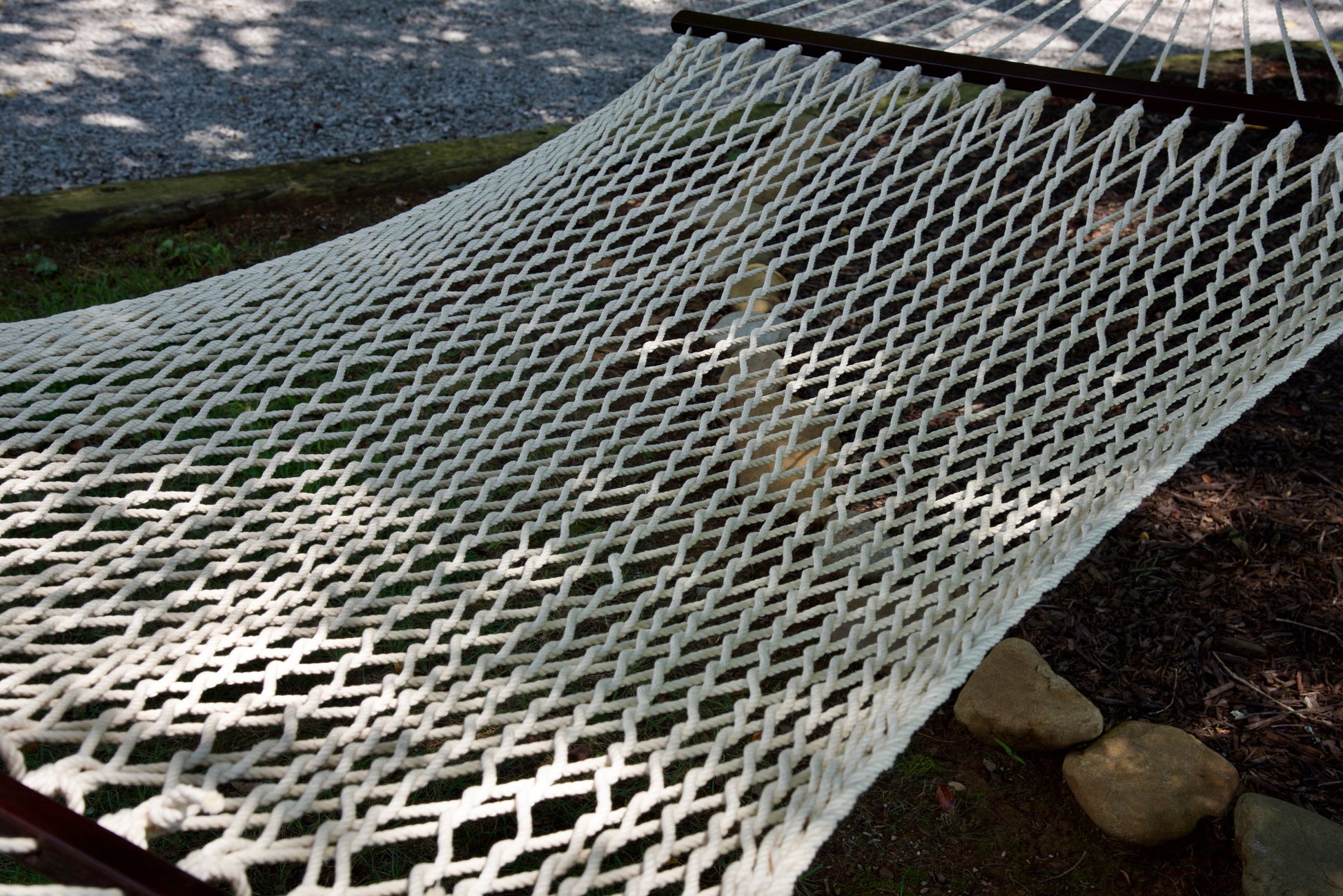 Close view of the Cream polyester rope bed and wood spreader bar of the Jumbo Rope Hammock.