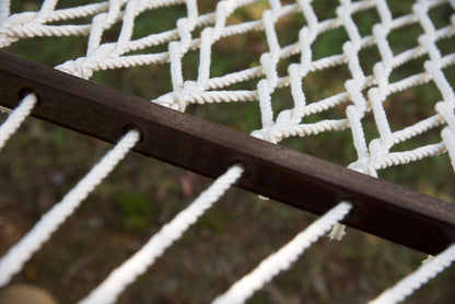 Close view of the varnished wood spreader bar and Cream polyester rope of the Jumbo Rope Hammock.