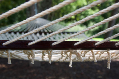 Close view of the Cream end cords threaded through the wood spreader bar of the Jumbo Rope Hammock.