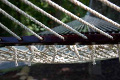 Close view of the Cream end cords threaded through the wood spreader bar of the Jumbo Rope Hammock.