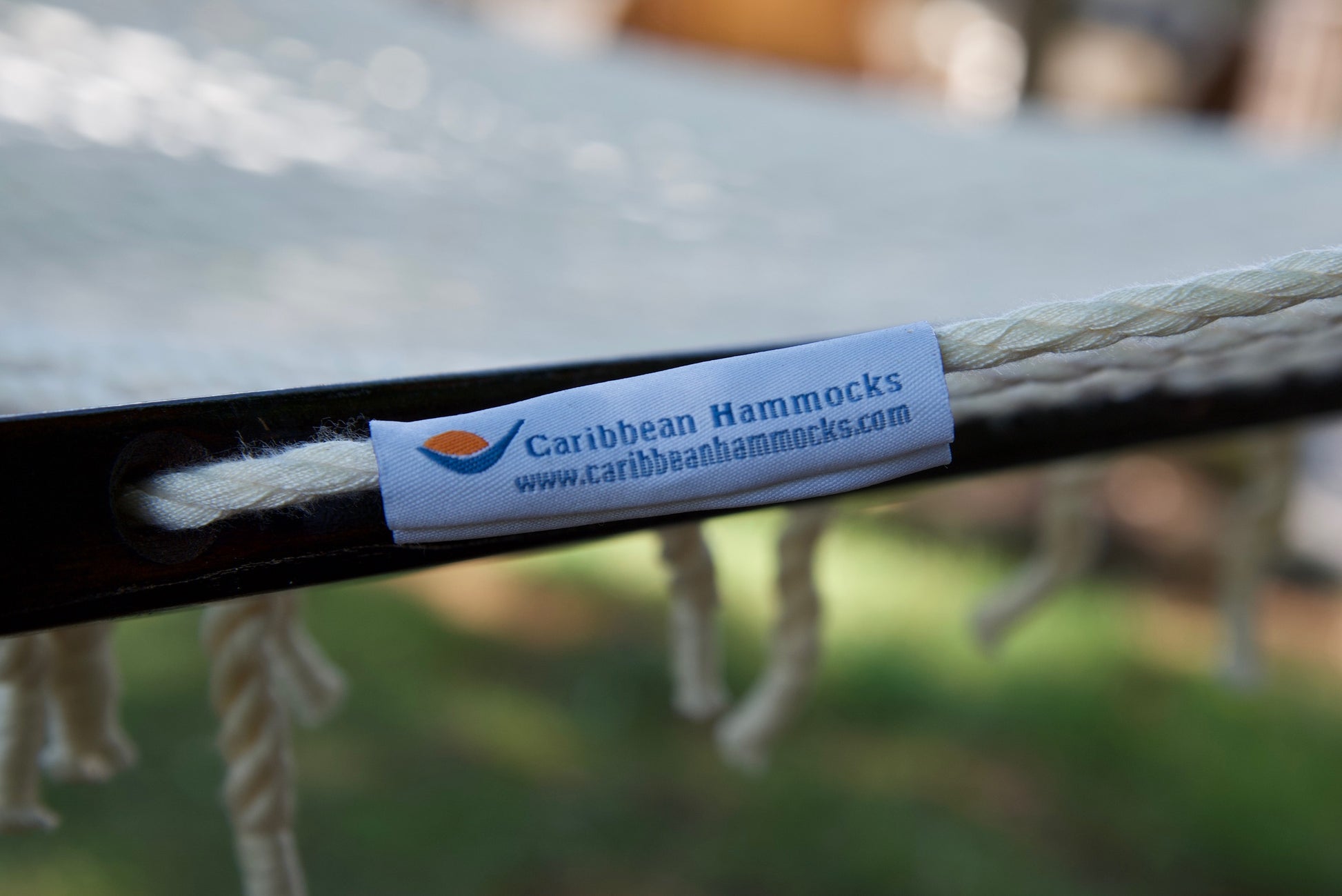 Caribbean Hammocks brand label on the wood spreader bar of the Cream Jumbo Rope Hammock.