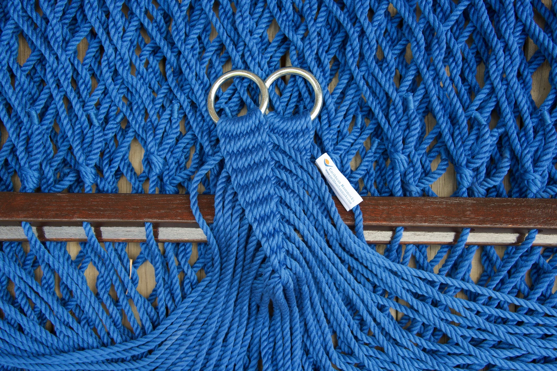 Close view of the gathered Dark Blue end cords and O-rings of the Jumbo Rope Hammock above the wood spreader bar.