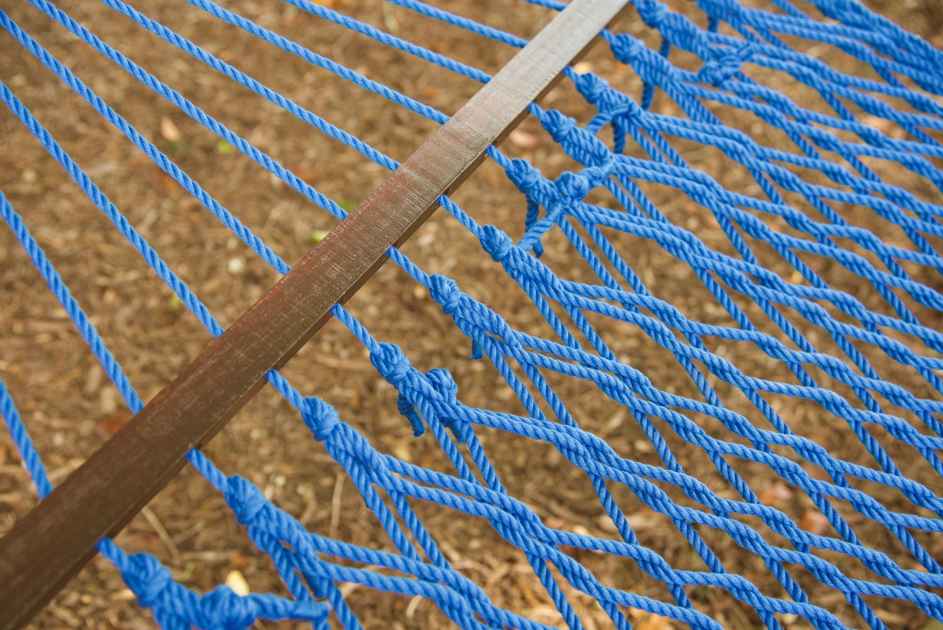 Close view of the varnished wood spreader bar and Dark Blue polyester rope of the Jumbo Rope Hammock.