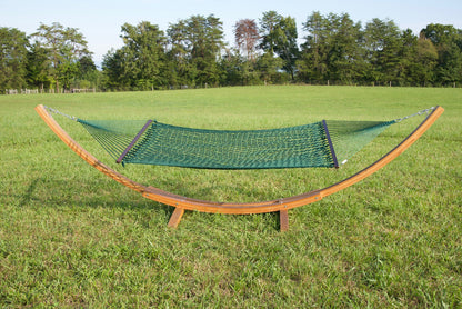 Green Jumbo Rope Hammock hanging on a Wood Arc Hammock Stand in an open grass field.