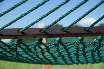Close view of the Green end cords threaded through the wood spreader bar of the Jumbo Rope Hammock.