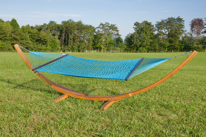 Light Blue Jumbo Rope Hammock hanging on a Wood Arc Hammock Stand in an open grass field.