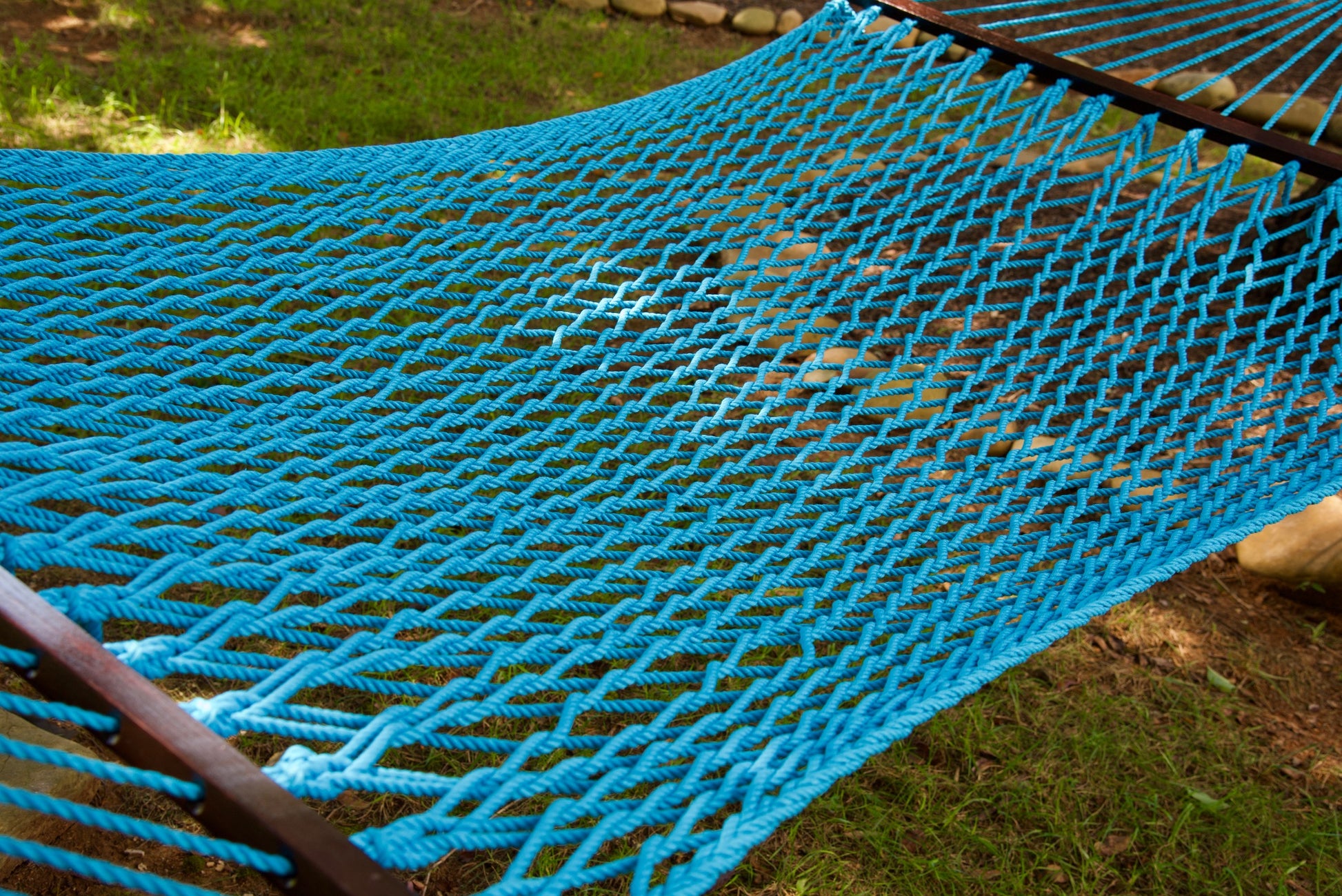 Close view of the Light Blue polyester rope bed and wood spreader bar of the Jumbo Rope Hammock.