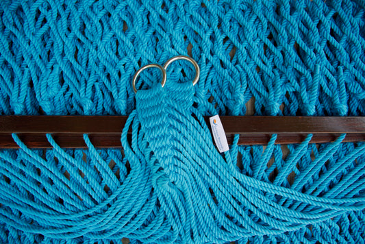 Close view of the gathered Light Blue end cords and O-rings of the Jumbo Rope Hammock above the wood spreader bar.