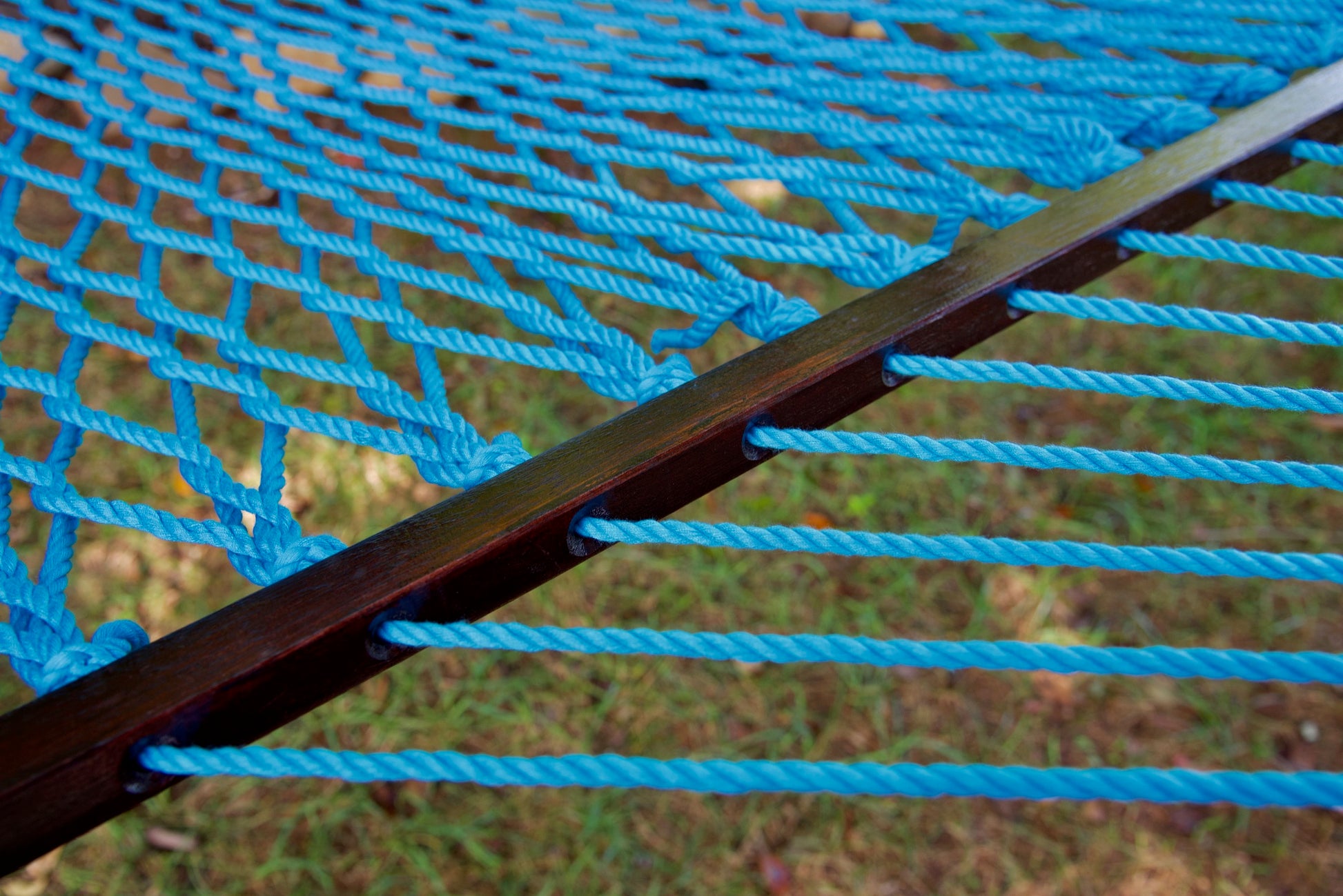 Close view of the varnished wood spreader bar and Light Blue polyester rope of the Jumbo Rope Hammock.