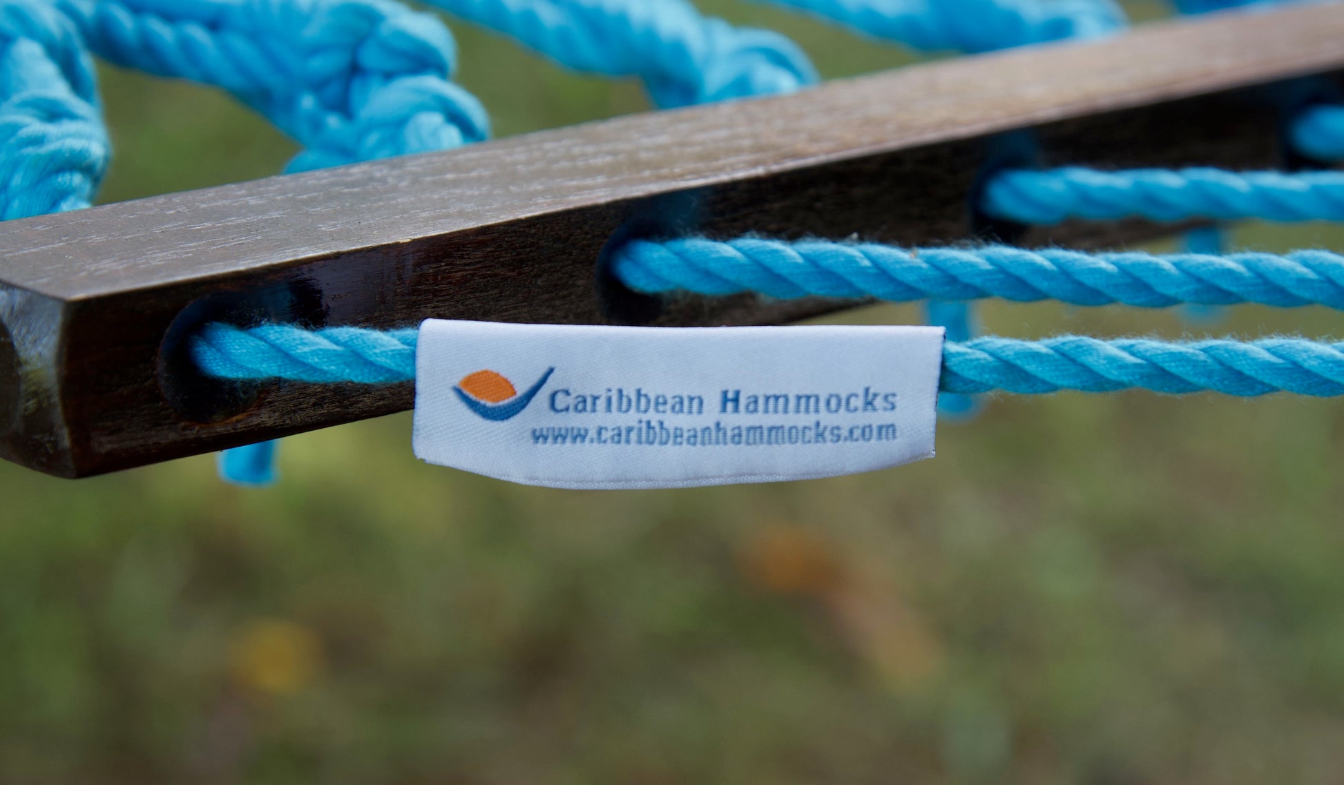 Caribbean Hammocks brand label on the wood spreader bar of the Light Blue Jumbo Rope Hammock.