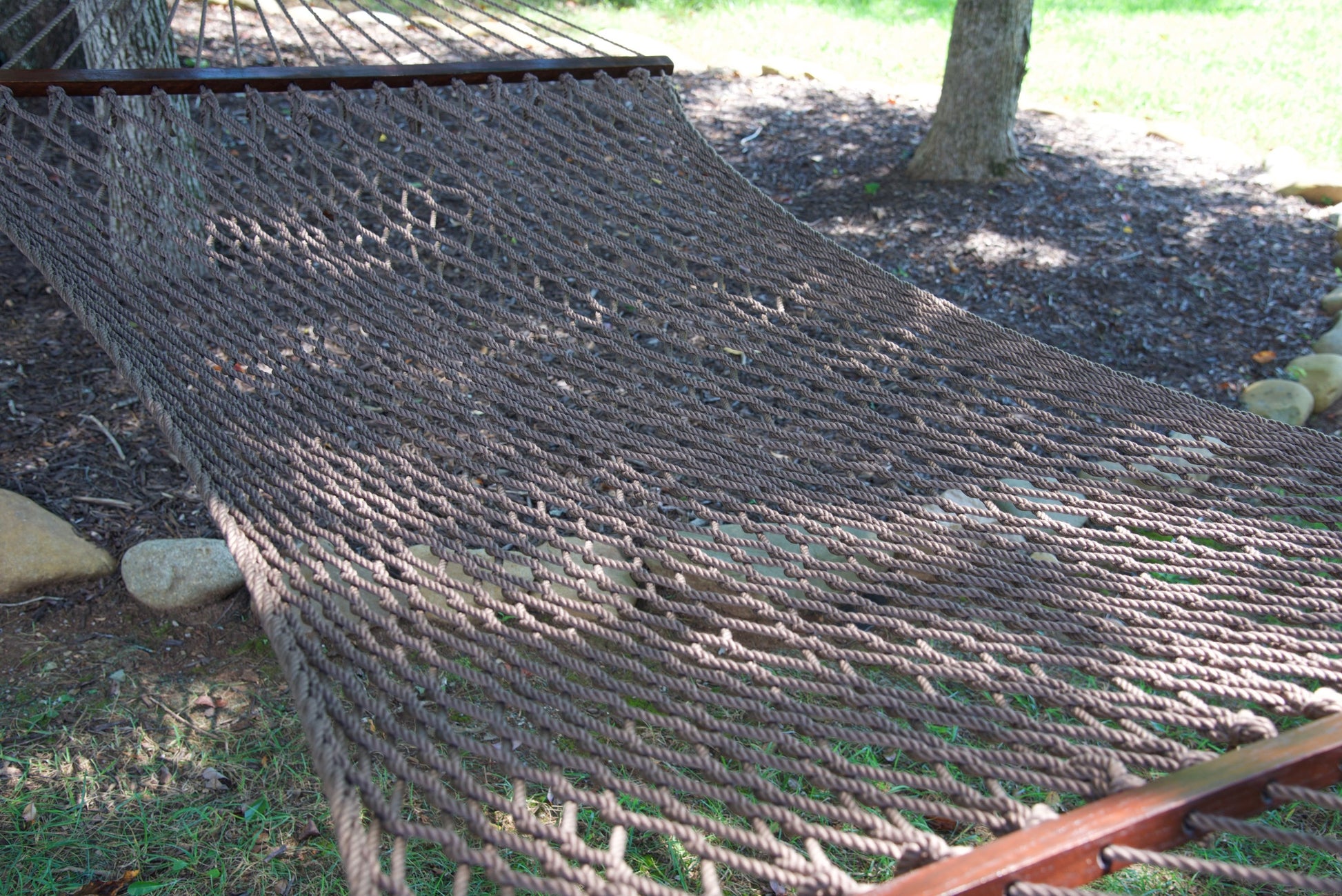 Close view of the Mocha polyester rope bed and wood spreader bar of the Jumbo Rope Hammock.