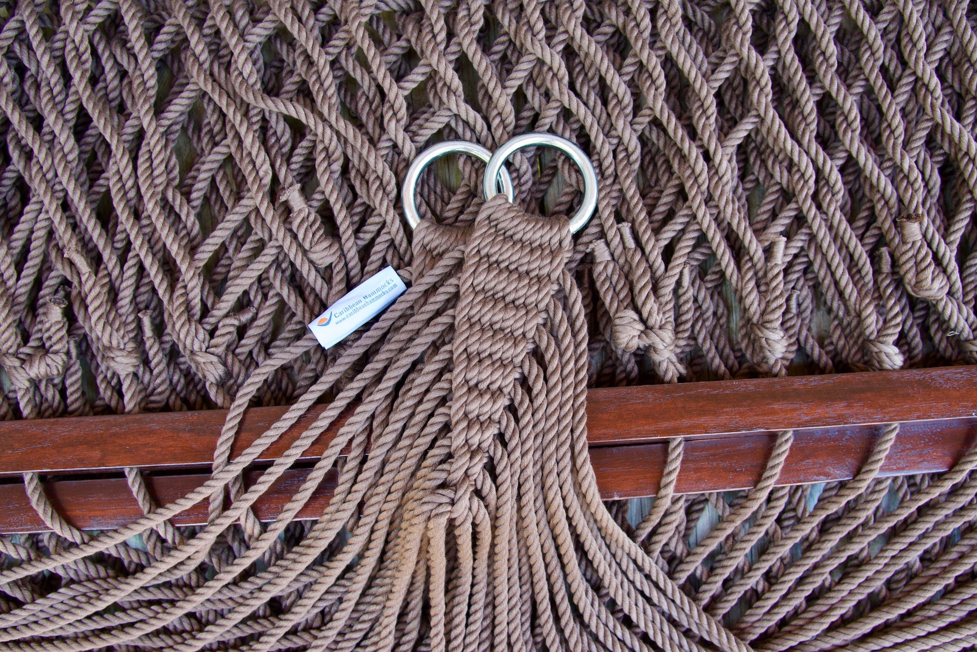 Close view of the gathered Mocha end cords and O-rings of the Jumbo Rope Hammock above the wood spreader bar.