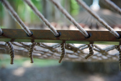 Close view of the Mocha end cords threaded through the wood spreader bar of the Jumbo Rope Hammock.