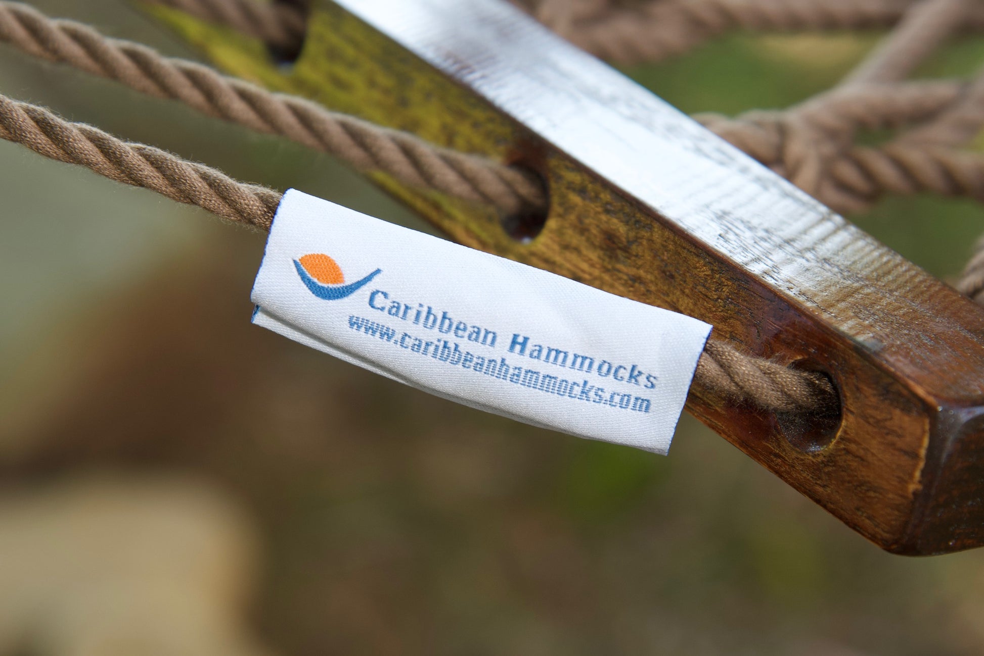 Caribbean Hammocks brand label on the wood spreader bar of the Mocha Jumbo Rope Hammock.