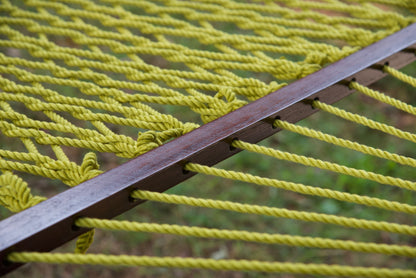Close view of the varnished wood spreader bar and Olive polyester rope of the Jumbo Rope Hammock.
