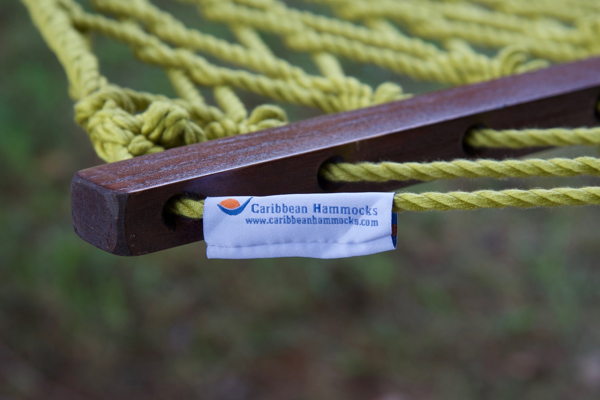 Caribbean Hammocks brand label on the wood spreader bar of the Olive Jumbo Rope Hammock.