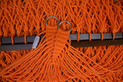 Close view of the gathered Orange end cords and O-rings of the Jumbo Rope Hammock above the wood spreader bar.