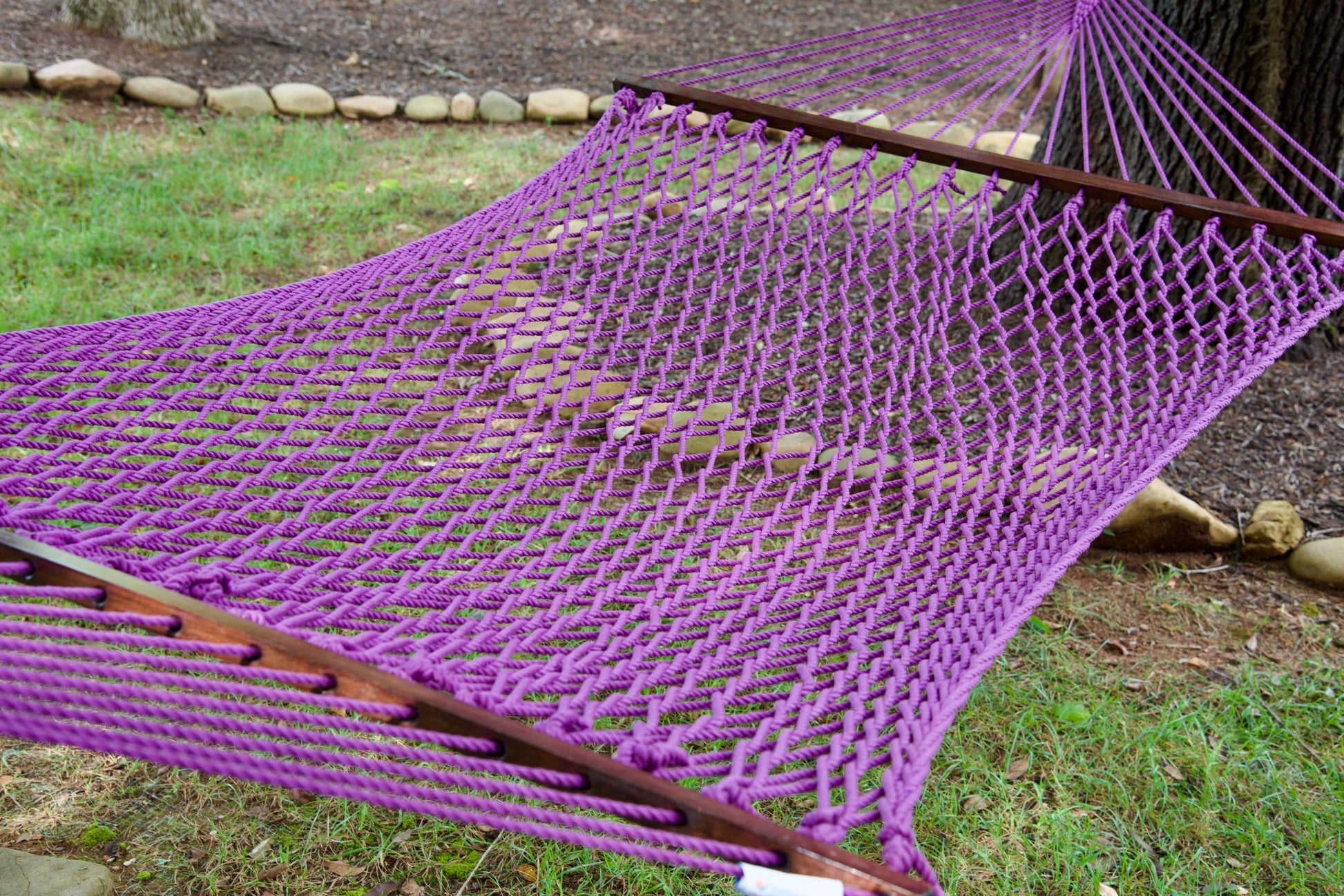 Close view of the Purple polyester rope bed and wood spreader bar of the Jumbo Rope Hammock.