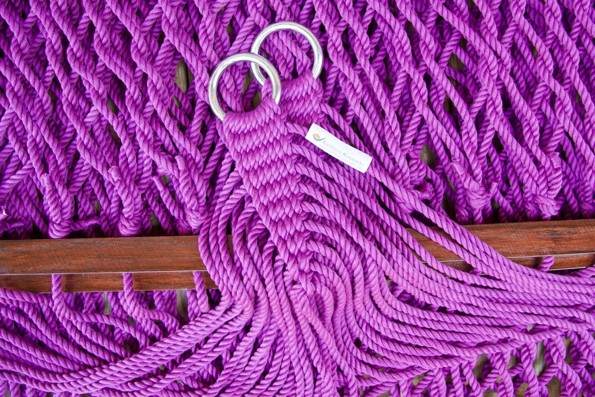 Close view of the gathered Purple end cords and O-rings of the Jumbo Rope Hammock above the wood spreader bar.