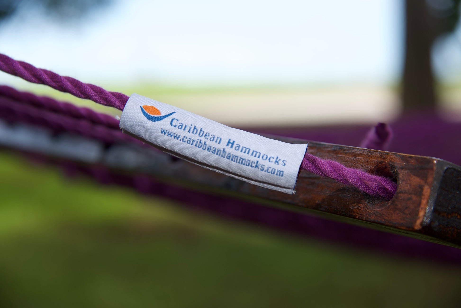 Caribbean Hammocks brand label on the wood spreader bar of the Purple Jumbo Rope Hammock.