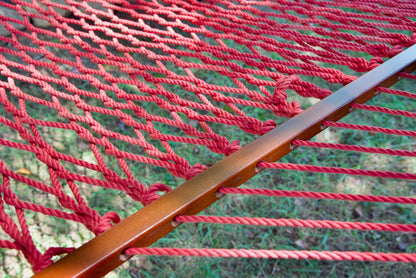 Close view of the varnished wood spreader bar and Red polyester rope of the Jumbo Rope Hammock.