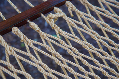 Close view of the varnished wood spreader bar and Tan polyester rope of the Jumbo Rope Hammock.