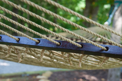 Close view of the Tan end cords threaded through the wood spreader bar of the Jumbo Rope Hammock.