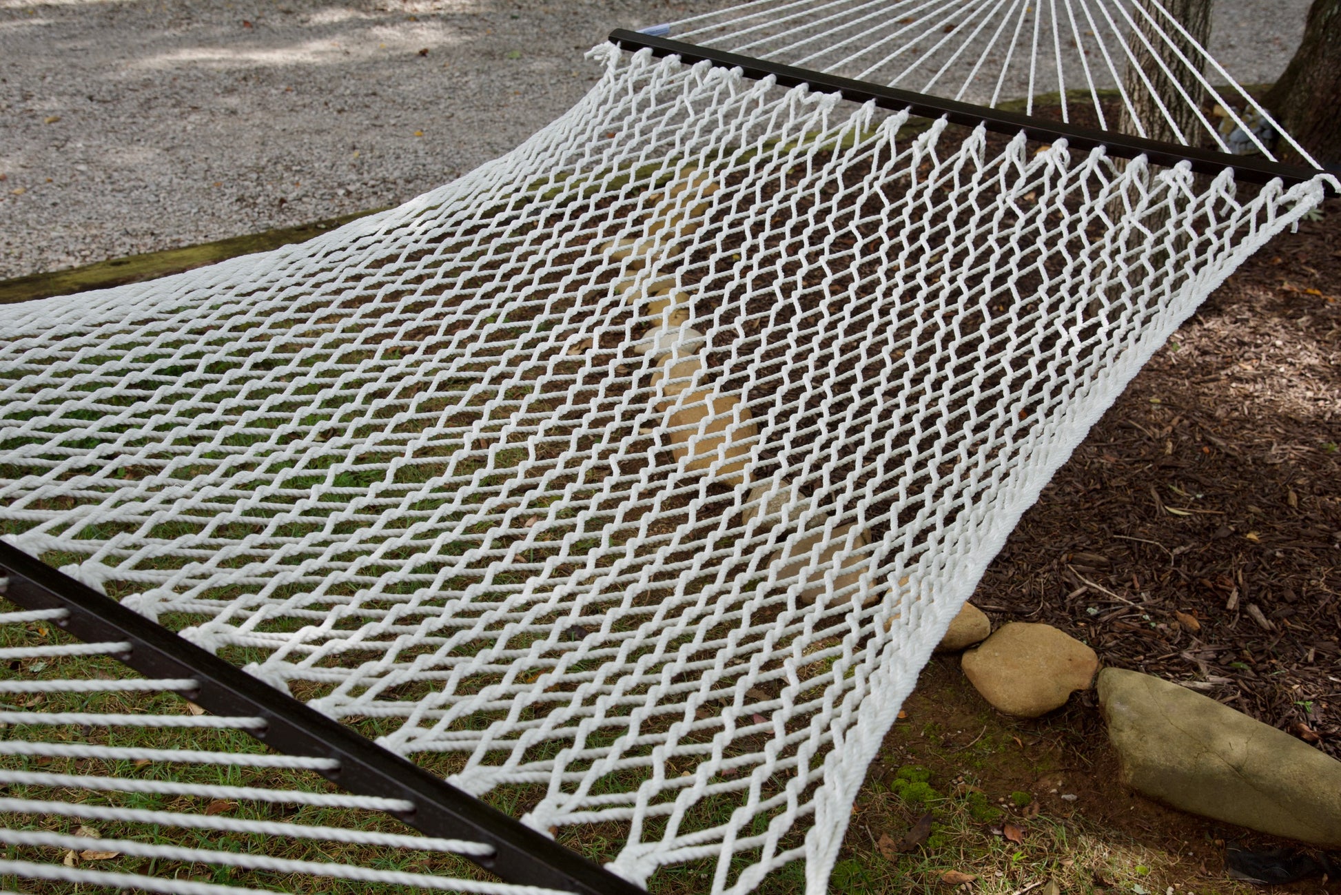 Close view of the White polyester rope bed and wood spreader bar of the Jumbo Rope Hammock.