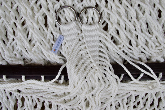 Close view of the gathered White end cords and O-rings of the Jumbo Rope Hammock above the wood spreader bar.