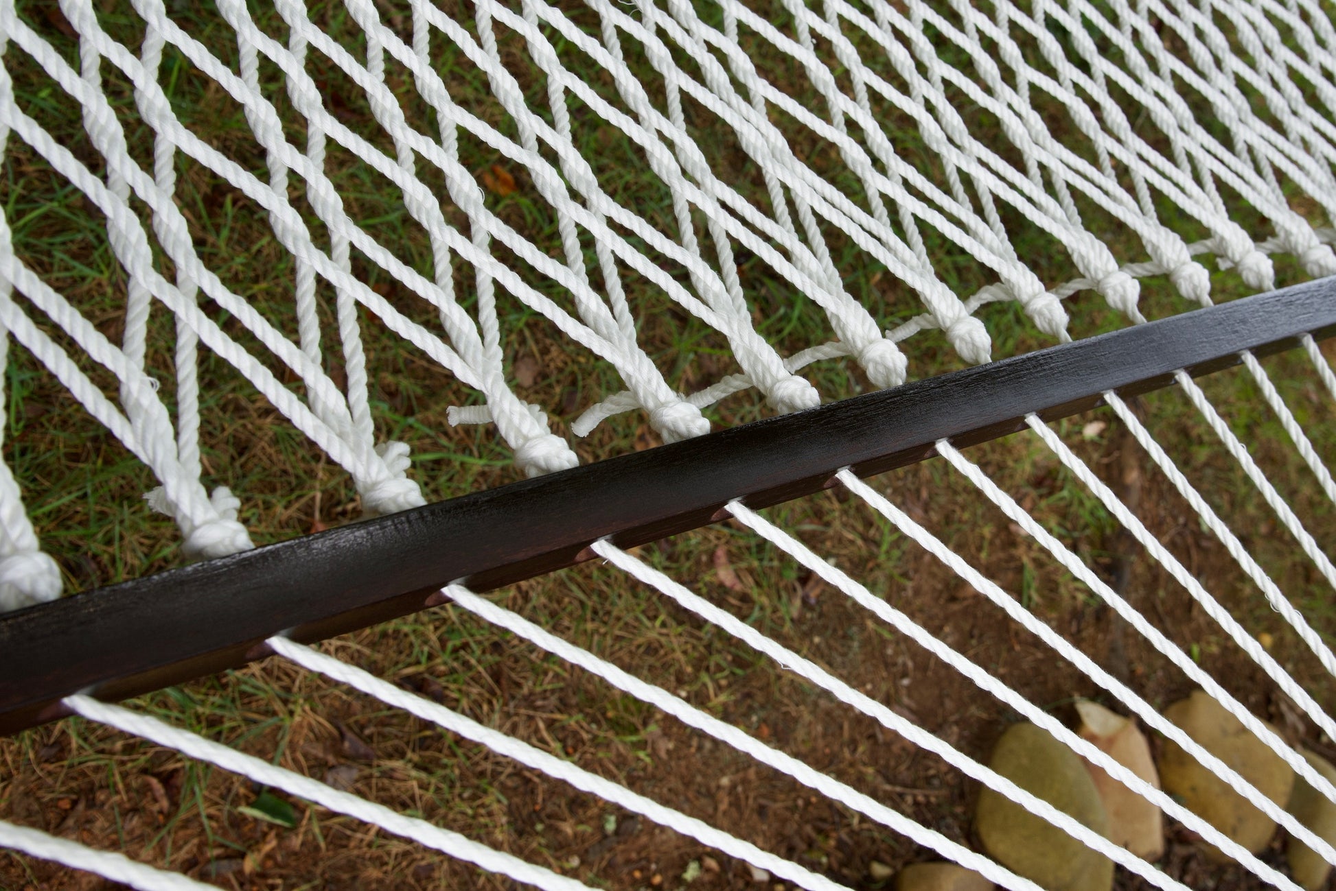 Close view of the varnished wood spreader bar and White polyester rope of the Jumbo Rope Hammock.