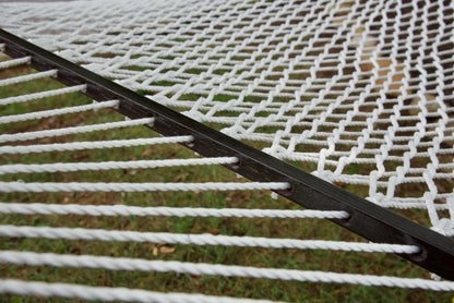 Close view of the varnished wood spreader bar and White polyester rope of the Jumbo Rope Hammock.