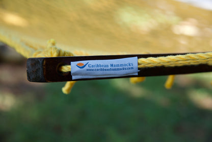 Caribbean Hammocks brand label on the wood spreader bar of the Yellow Jumbo Rope Hammock.