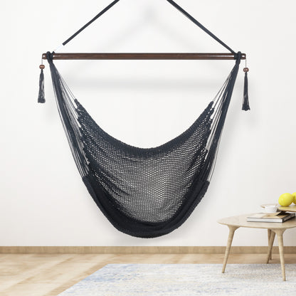 Black Large Caribbean Hammock Chair hanging indoors beside a small round side table against a cream wall
