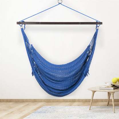 Dark blue Jumbo Caribbean Hammock Chair hanging indoors beside a small round side table against a cream wall