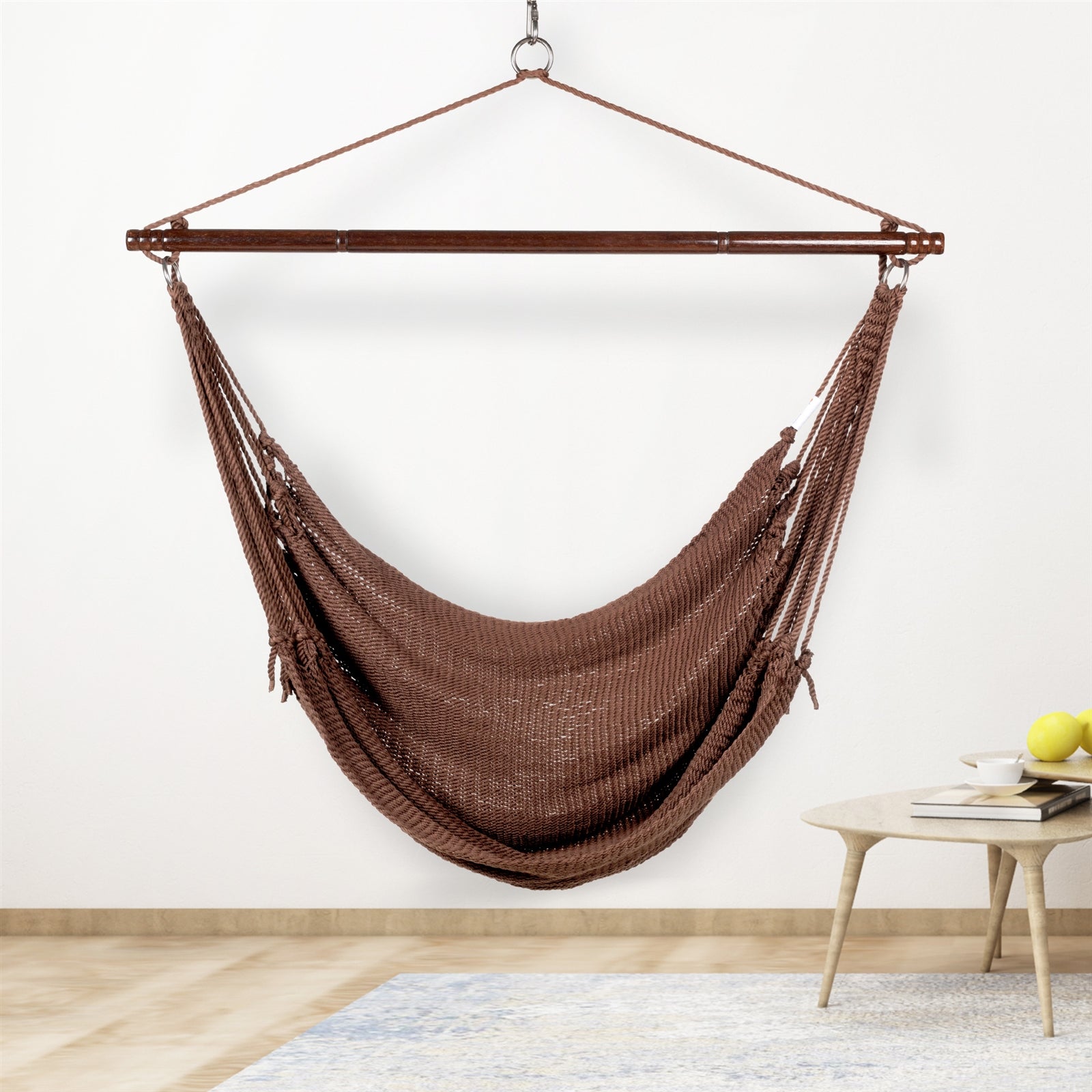 Mocha Jumbo Caribbean Hammock Chair hanging indoors beside a small round side table against a cream wall