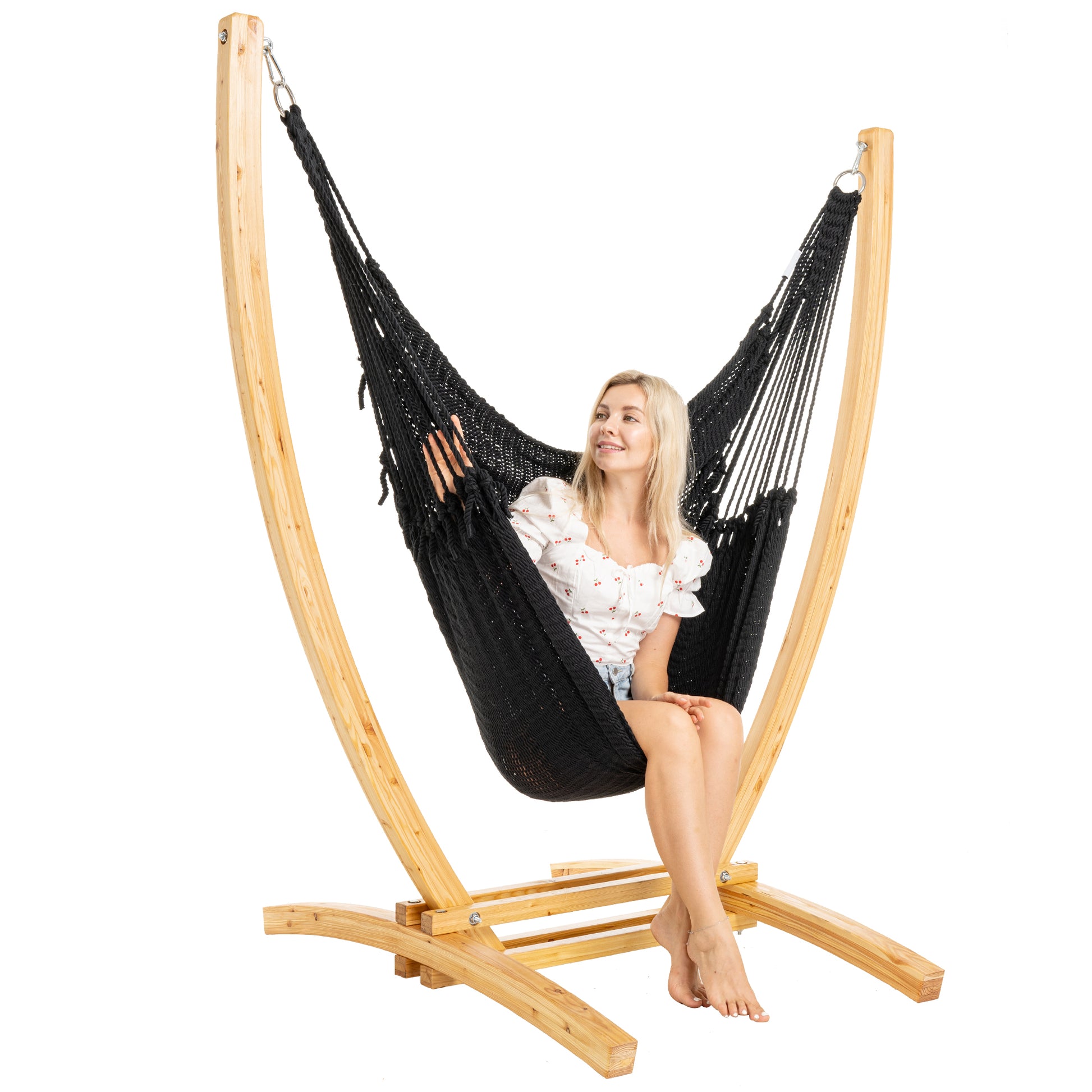 Black Jumbo Caribbean Recliner on a Siberian larch wood arc stand, woman seated, three-quarter view