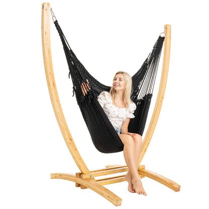 Black Jumbo Caribbean Recliner on a Siberian larch wood arc stand, woman seated, three-quarter view