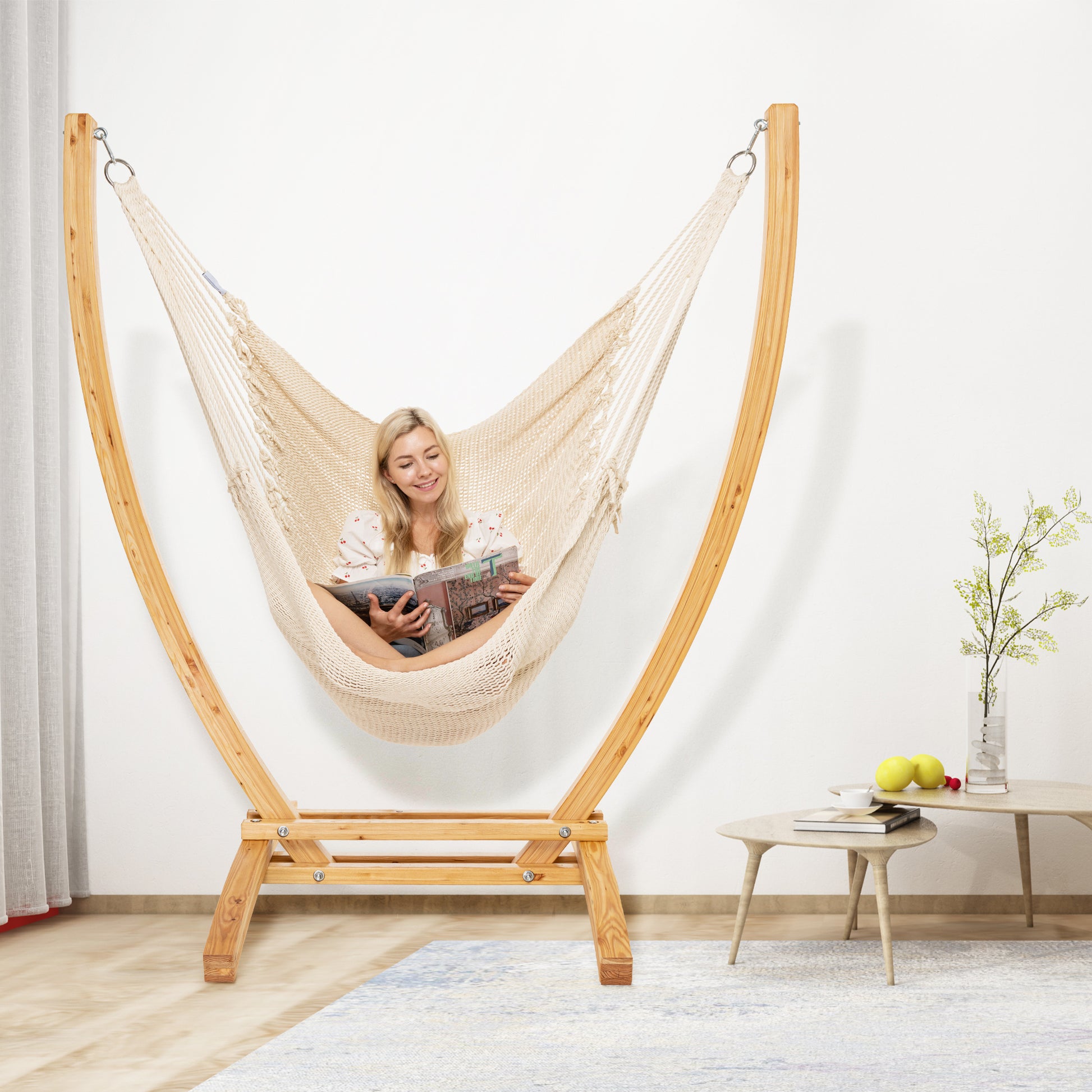 Cream Jumbo Caribbean Recliner on a wood arc stand in a living room beside a low round side table