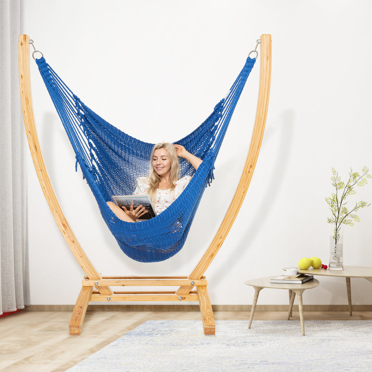 Dark Blue Jumbo Caribbean Recliner on a wood arc stand in a living room beside a low round side table