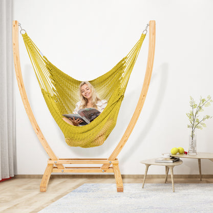 Olive Jumbo Caribbean Recliner on a wood arc stand in a living room beside a low round side table
