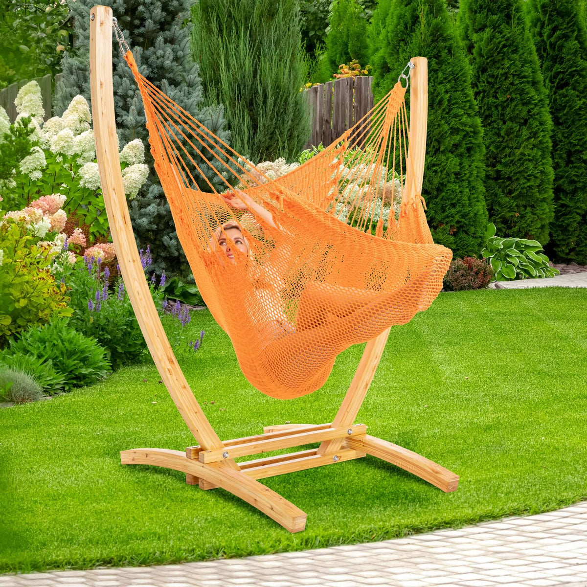 Orange Jumbo Caribbean Recliner on a wood arc stand in a backyard beside flowering hydrangeas