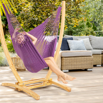 Purple Jumbo Caribbean Recliner on a wood arc stand on a deck beside a wicker sofa