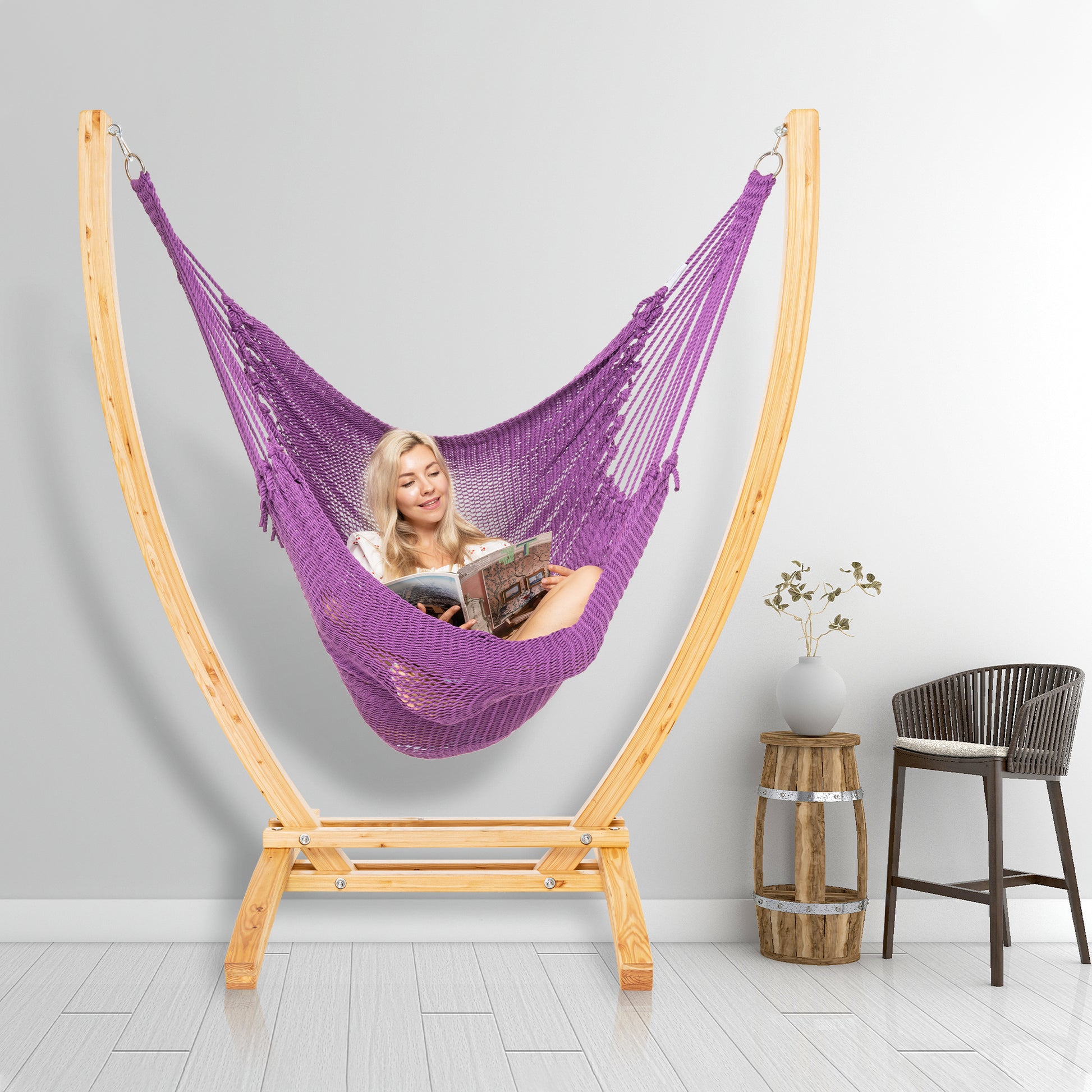Purple Jumbo Caribbean Recliner on a wood arc stand in a styled interior corner beside a woven barstool